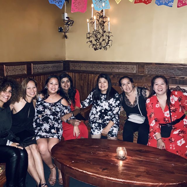 A group of friends smiling together at a Salsa Dance LA salsa-and-mojitos night